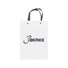 White shopping bag with BERKE logo and black handles.