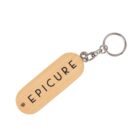 Wooden keychain with the word EPICURE engraved; attached to a metal ring.