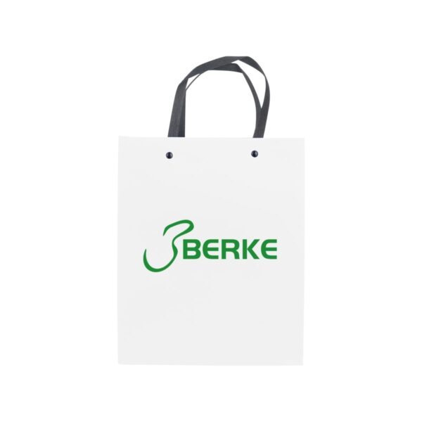 White shopping bag with green BERKE logo and black handles.