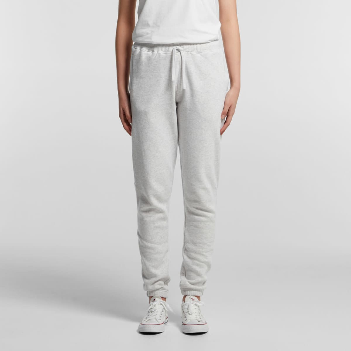 Person wearing light gray sweatpants, white t-shirt, and white sneakers, standing upright.