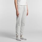 Person wearing light gray sweatpants, white t-shirt, and white sneakers on a plain background.