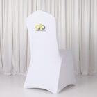 White chair with a branded cover in front of white curtains.