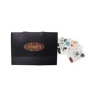 Black gift bag with floral sticker design and assorted colorful stickers beside it.