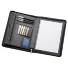 Open black leather portfolio with pens, sticky notes, and a lined notebook inside.