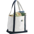 Canvas tote bag filled with items including clothes, a book, and pens in the front pocket.