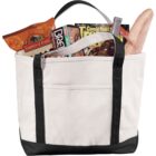 Canvas tote filled with snacks, bread, magazines, and a bottle.