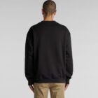 Person in a black sweatshirt and khaki pants, standing with their back to the camera.