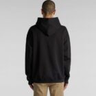 Person in black hoodie, beige pants, facing away.