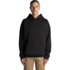 Person wearing a black hoodie and beige pants against a white background.