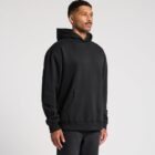 Person wearing a black hoodie and jeans against a plain background.