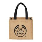 Jute tote bag with black handles and The Body Shop logo.