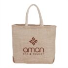 Beige tote bag with aman SPA & RESORT logo and floral design.