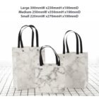 Three marble-patterned tote bags in different sizes with black handles displayed.