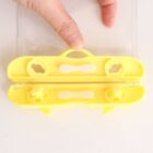 Yellow device held by fingers, resembling a double-sided zipper lock.