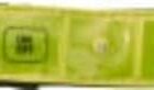 A close-up view of a two-toned belt, featuring a black fabric section on the left and a lime green, shiny material with silver eyelets on the right.