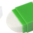 White oval eraser with a green holder and a clear, removed cap placed next to it.