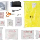 First aid kit with bandages, scissors, safety pin, and yellow poncho.