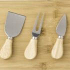 Cheese knives set on a wooden cutting board.