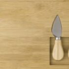 Wooden board with three cheese tools inset: a knife, fork, and chisel.