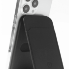 A phone with a black magnetic wallet stand attached to its back, standing upright.
