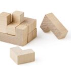 Wooden puzzle blocks arranged and scattered on a white background.