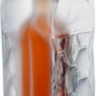 Bottle in a clear ice bag with handles and hexagonal patterns.