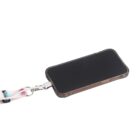 A smartphone in a clear case is attached to a colorful lanyard. The screen is black, and the lanyard features playful designs in various colors. The phone is angled slightly, displaying a side button. The background is white.