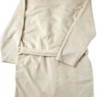 A beige bathrobe laid flat, seen from the back.