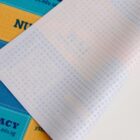 Close-up of a colorful, patterned sheet partially covering a yellow and blue printed surface.