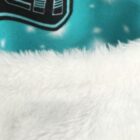 Close-up of fluffy white fabric with a teal background featuring a black and white pattern.