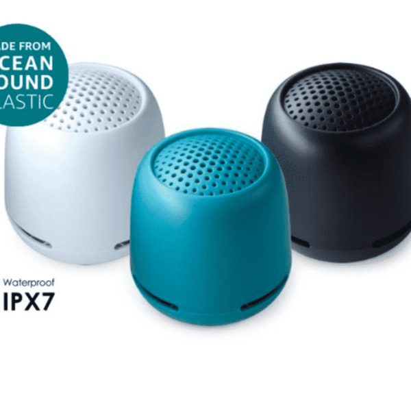 Three portable speakers in white, blue, and black with a perforated design. The text indicates they are made from ocean-bound plastic and are IPX7 waterproof.