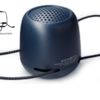 A small, dark blue portable speaker with a perforated top on a white background. It has a cord looped around the base and the label Zero XL and Bungee Anywhere next to a minimalist drawing of a bag.