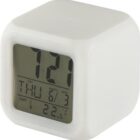 White digital alarm clock displaying time, date, weekday, and temperature on its screen.