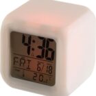 A digital alarm clock displaying time, date, day, and temperature on its screen.