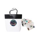 White gift bag with Thank you and various colorful stickers beside it.