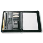 An open black leather portfolio with a lined notepad on the right. The left side holds a calculator, two pens, a zippered pocket, and card slots.