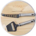 Cheese knife and slicer set on a round wooden board.