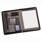 An open black leather portfolio displaying a pen holder, note slots with colored page markers, a zippered compartment, and a large pad of lined paper on the right.