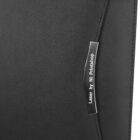 Close-up of a black leather surface with a silver metallic tag displaying the text Laser by NI Printshop. The tag is curved and attached to the material, creating a sleek and modern look.