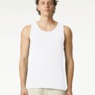 Man wearing a white sleeveless tank top and light pants, standing against a plain background.