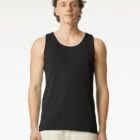 A man wearing a black tank top and light pants stands facing forward against a white background.