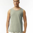A man in a gray tank top and light pants stands facing forward against a white background.