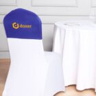 Chair with a blue cover and doxer logo beside a set dining table.