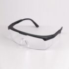 Clear-lens safety glasses with black frames on a white background.