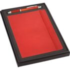 A red notebook with an elastic band and a matching red pen in a black gift box, surrounded by foam padding.