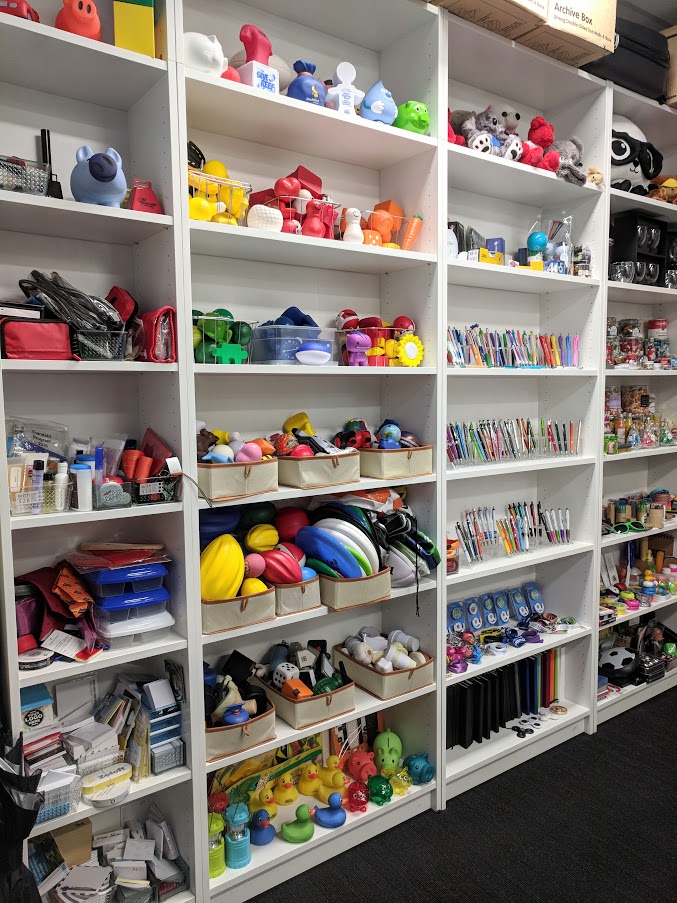 Showroom Wall of promotional items. Features cabinets filled with promotional products