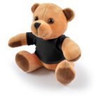 Plush teddy bear wearing a black T-shirt, sitting on a white background.