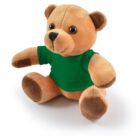 Plush brown teddy bear wearing a green shirt, sitting on a white background.