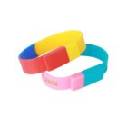 Two interlocking colorful silicone wristbands with blocks of yellow, red, blue, and pink.