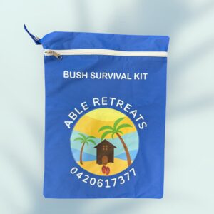 Blue pouch with white zipper, labeled Bush Survival Kit. Features a logo with a beach scene, including palm trees and a hut, below the text Able Retreats and contact number 0420617377. This vibrant promotional product showcases a soft gradient of blues.